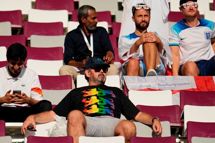 An England fan wearing a rainbow shirt sits in the stands prior to the start of the World Cup group B soccer match between England and Iran